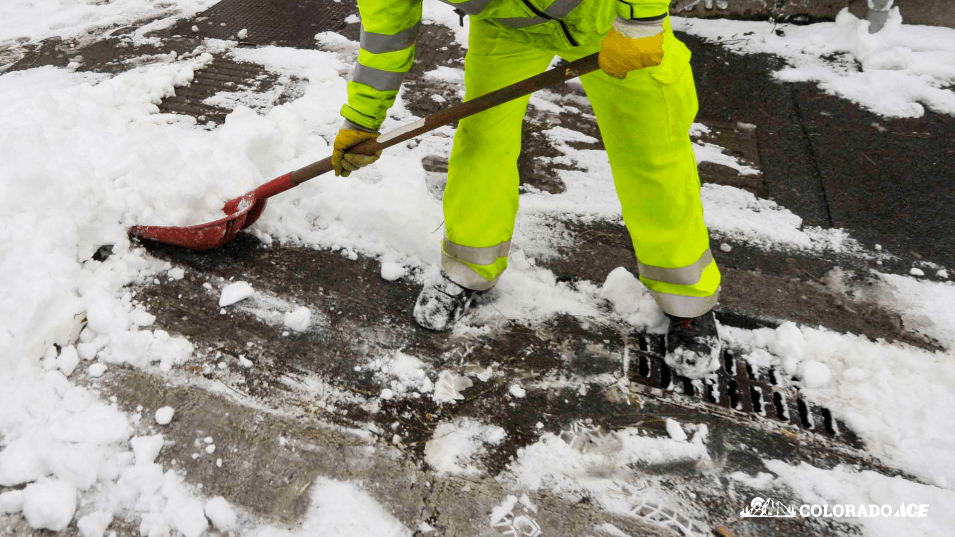 Facility worker clearing snow and ice during winter maintenance routine in Colorado