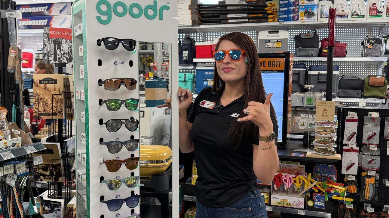 Summit County – Mariana goodr: Mariana from Colorado Ace Summit County wearing goodr sunglasses beside the store’s sunglasses display.