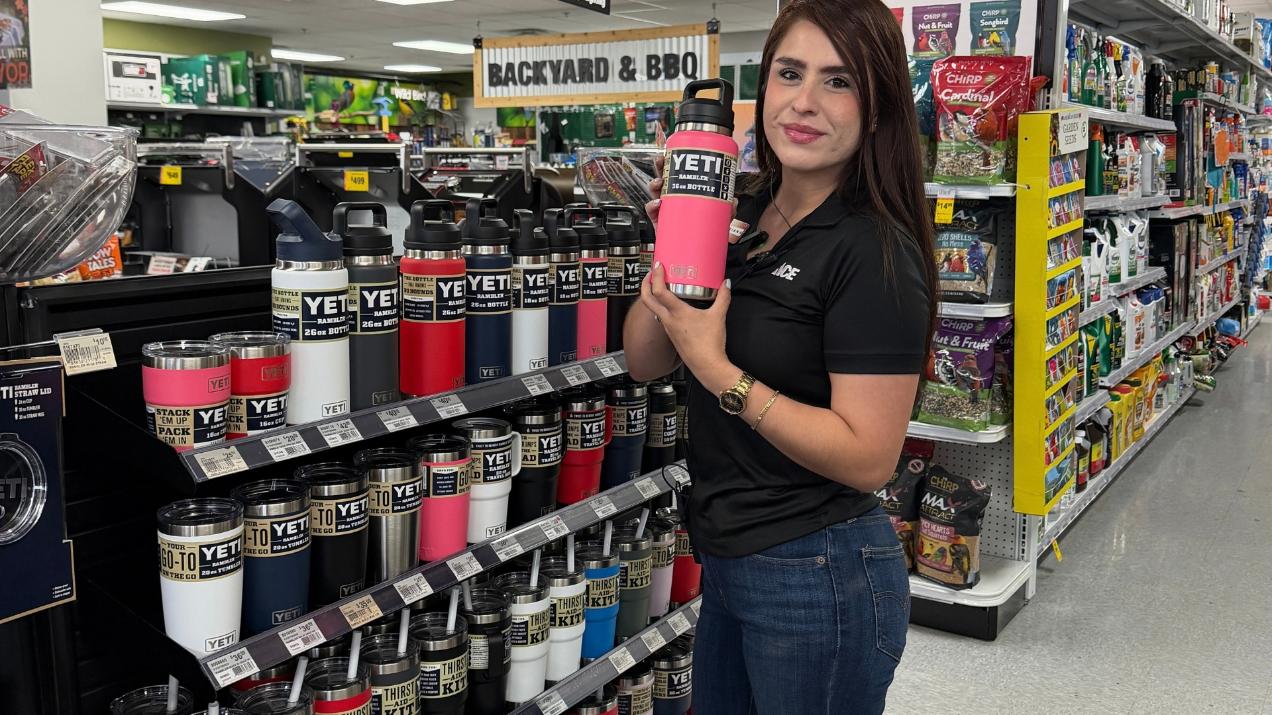Summit County – Mariana YETI: Mariana from Colorado Ace Summit County holding a pink YETI Rambler bottle beside a display of YETI drinkware.