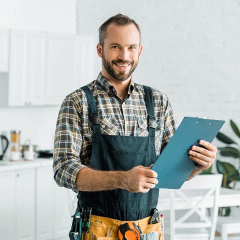 Handyman standing in customer's kitchen discussing project at hand