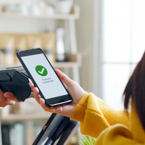 Woman using her mobile phone to make a payment