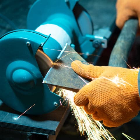 Worker professionally sharpening a small axe