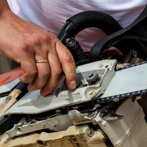 Repairman taking apart chainsaw to fix it