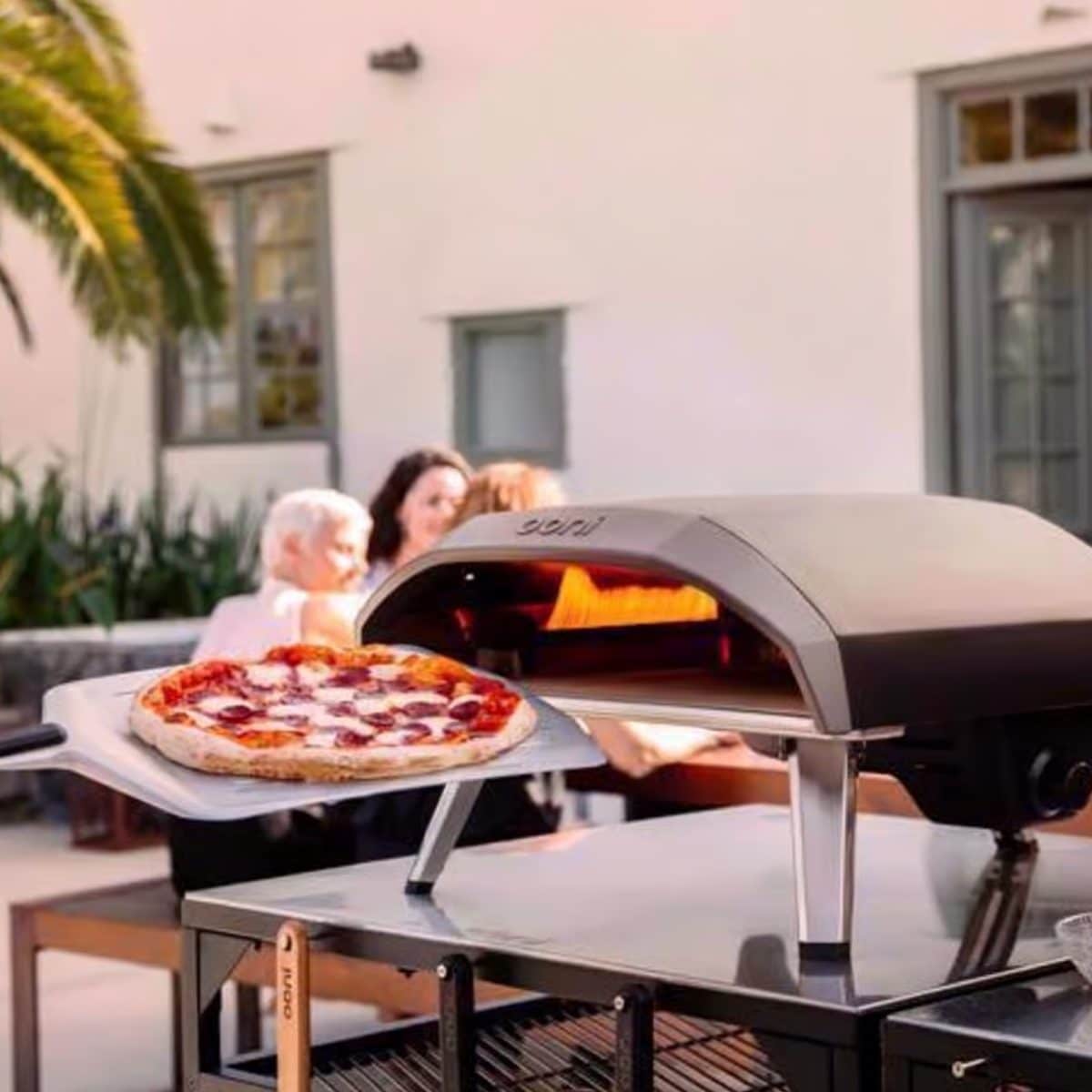 Outdoor pizza oven setup creating wood-fired pizza for backyard entertaining
