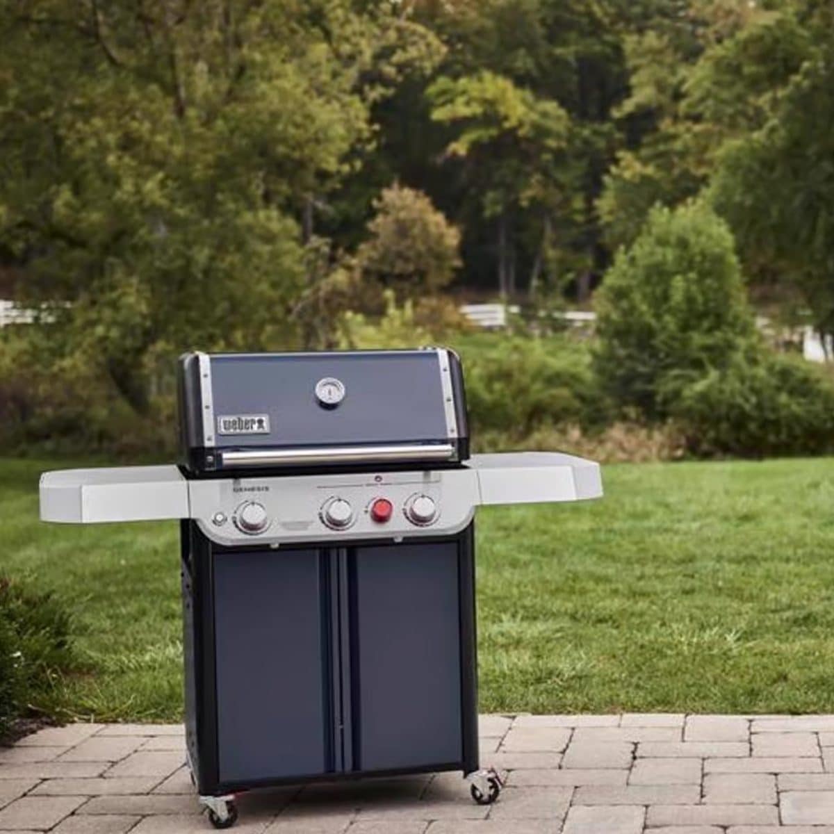 Weber propane grill in backyard patio setting ready for summer BBQ cooking