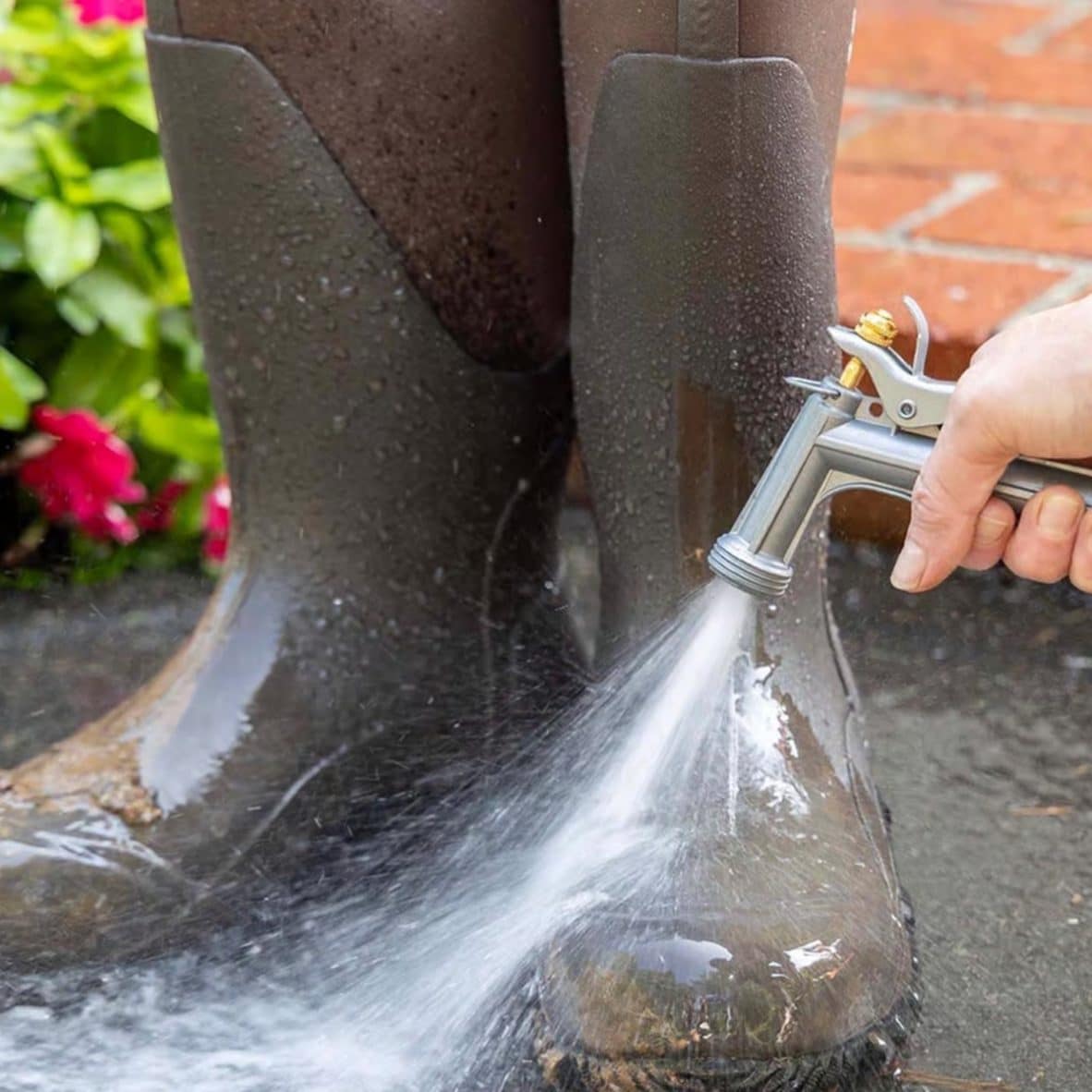 Metal garden hose nozzle spraying water for outdoor cleaning and watering tasks