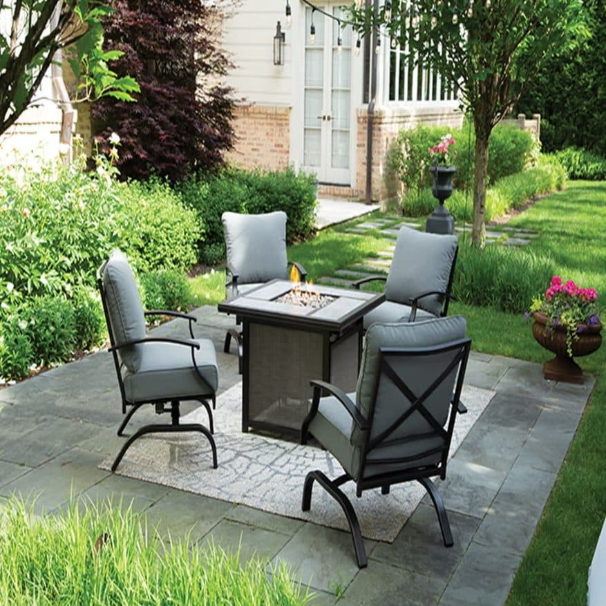 Backyard patio seating area with fire pit table and outdoor conversation chairs