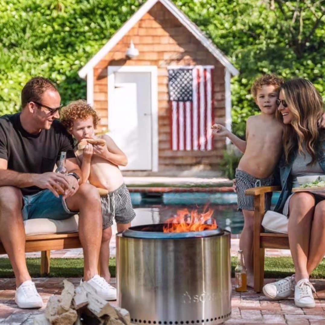 Solo Stove fire pit with family gathered around for outdoor backyard entertaining
