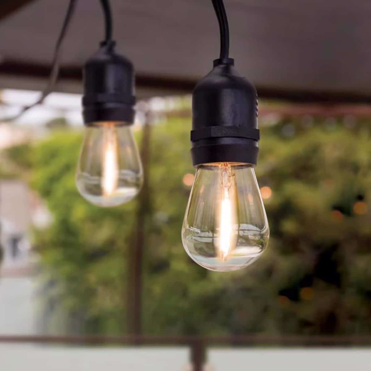 Outdoor string lights hanging above patio space for backyard evening lighting