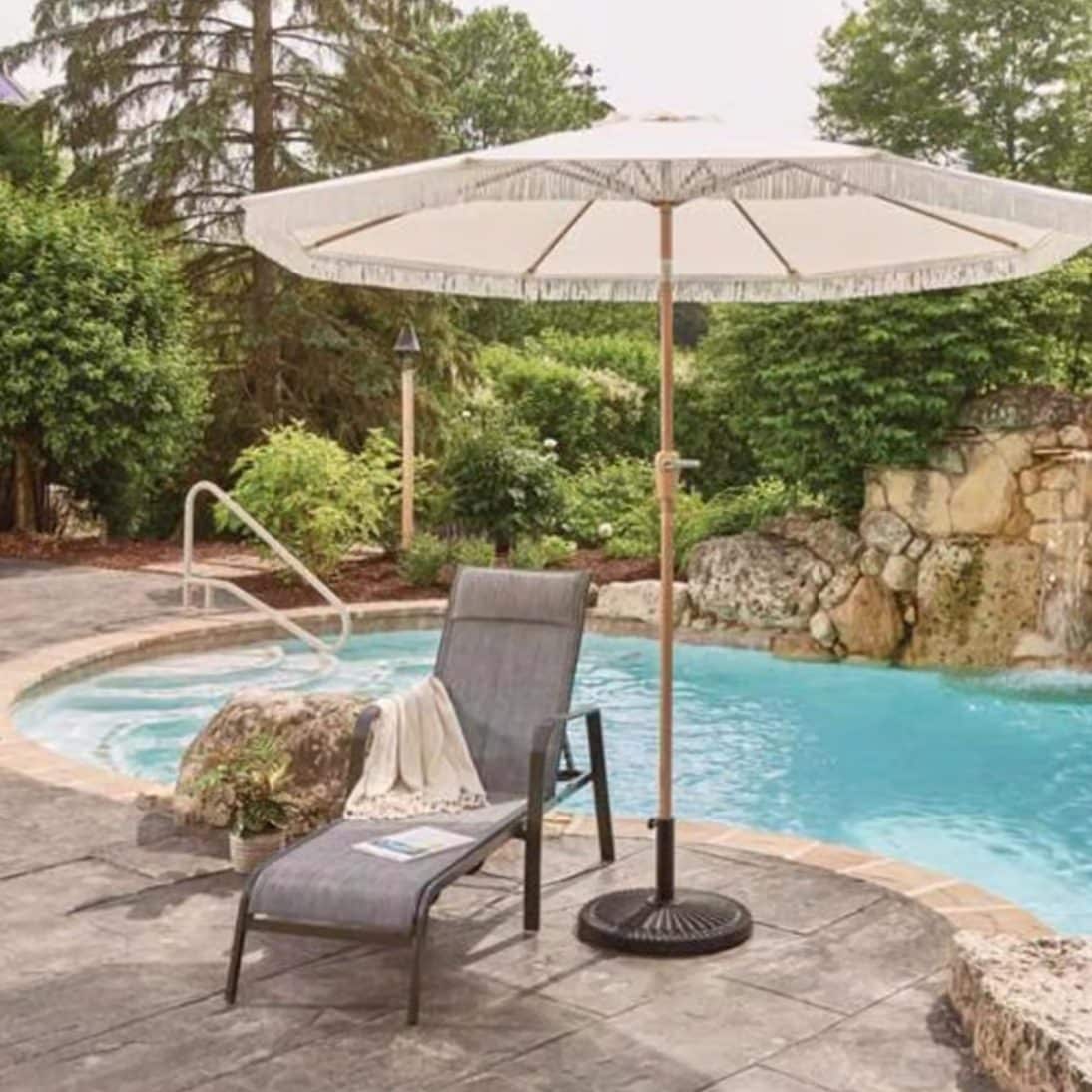 Patio umbrella and lounge chair setup beside backyard pool for outdoor shade