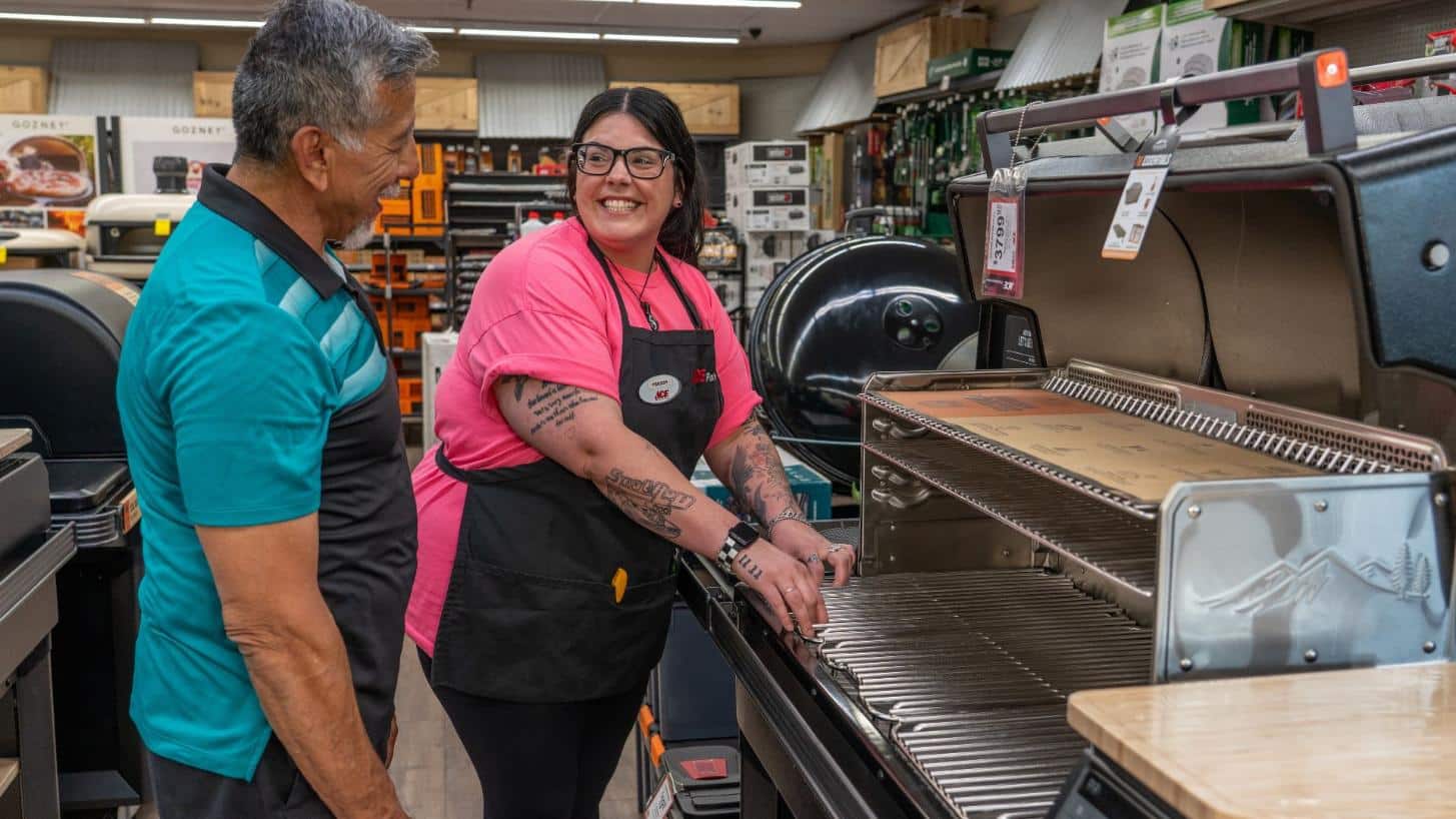 Colorado Ace employee helping a customer choose a new gas grill in the grilling department.
